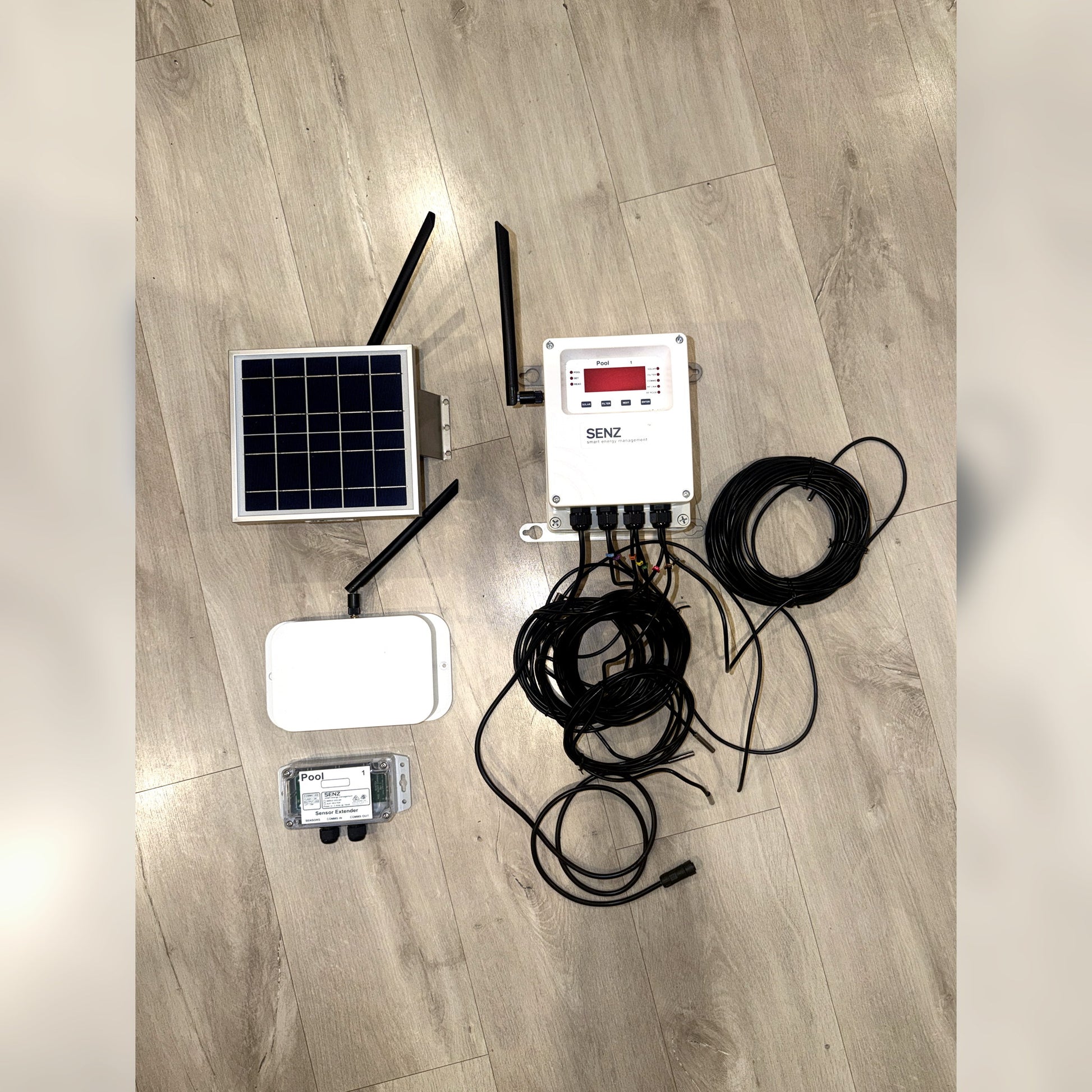 PSH Pool Buddy controller kit laid out with solar panel, sensor extender and cabling